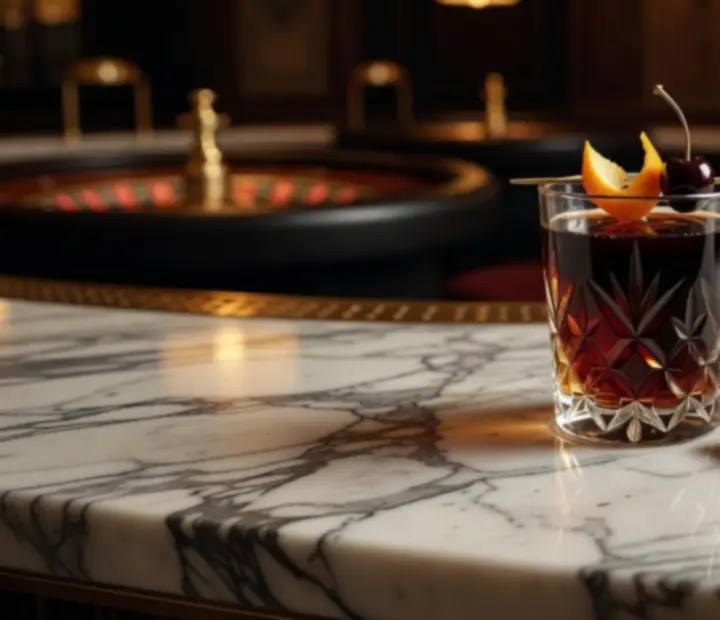 Cocktail signature coloré dans un verre élégant, posé sur une table raffinée.